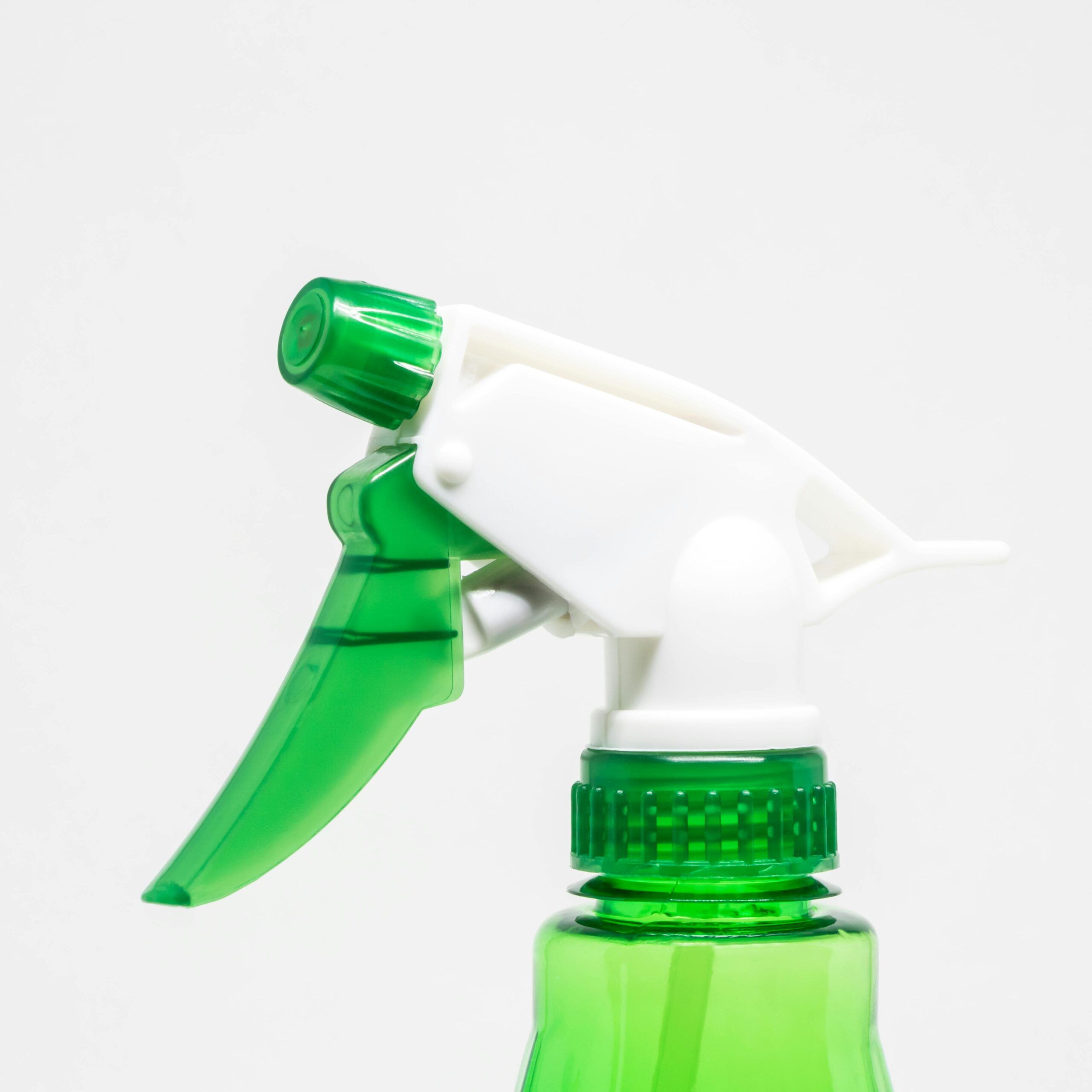 a close up of a spray bottle containing a green chemical cleaning solution