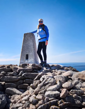 julie milne superfine managing director stands on a mountain peak